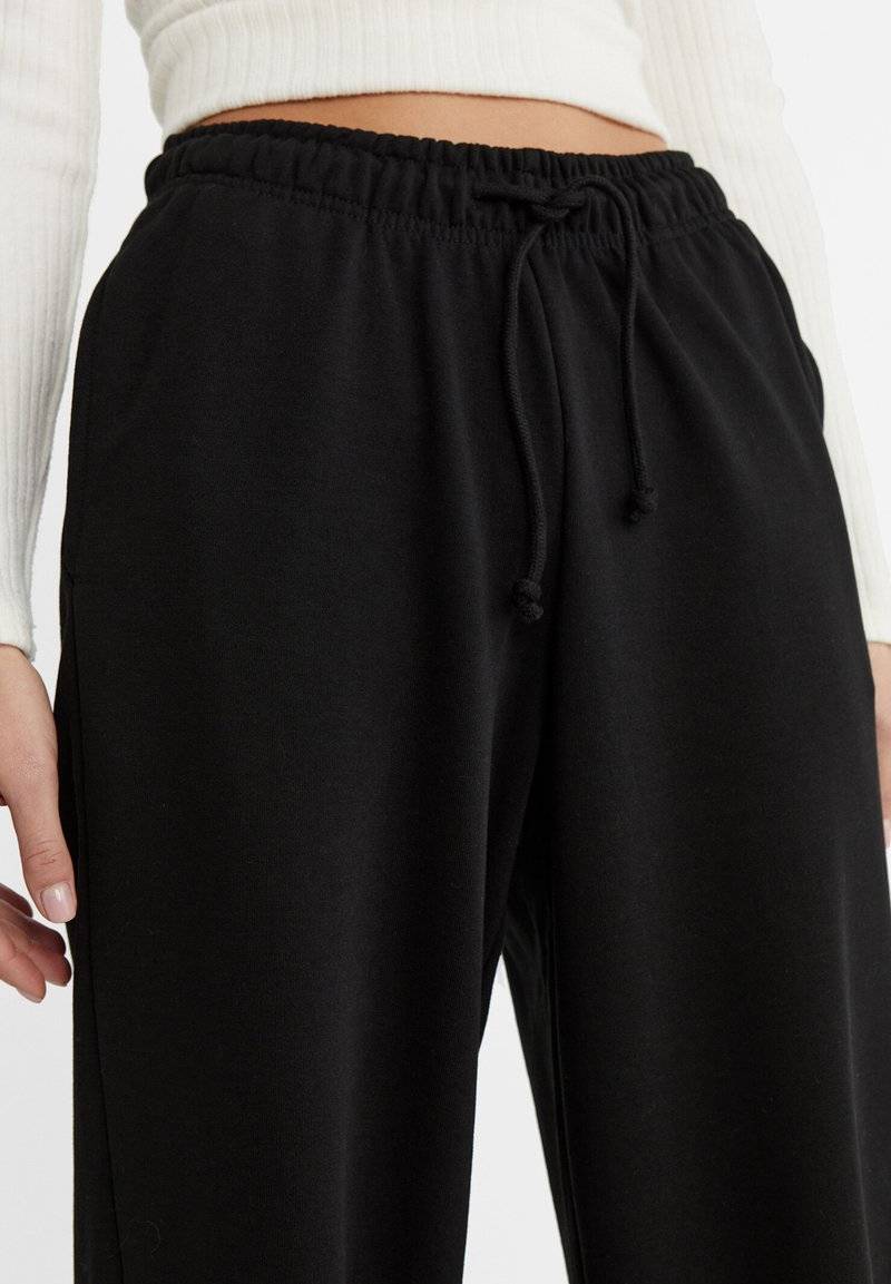 Stradivarius Stradivarius WIDE-LEG JOGGER - Tracksuit bottoms - black Speichern exportieren