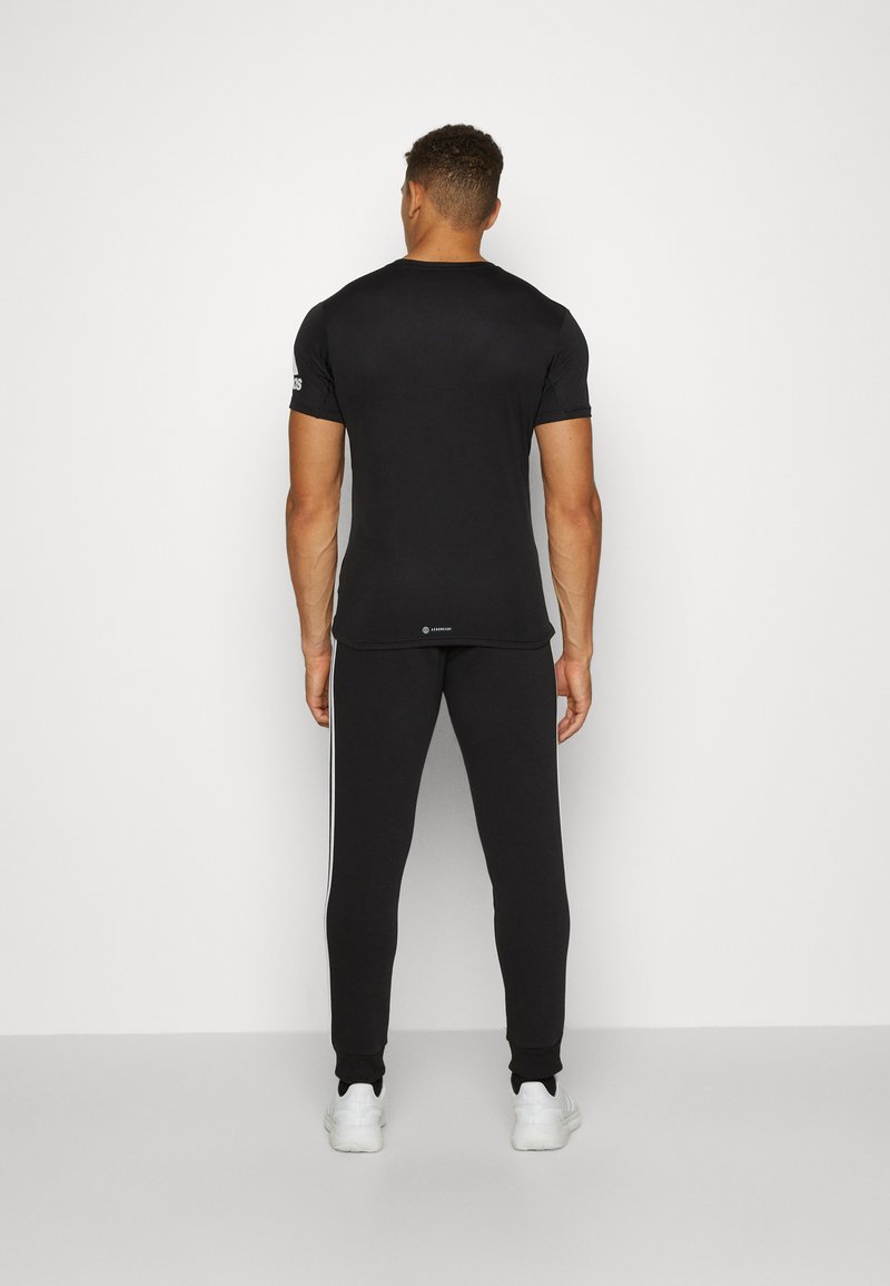 adidas Sportswear adidas Sportswear ESSENTIALS TAPERED CUFF 3 STRIPES PANTS - Tracksuit bottoms - black white Schlussverkauf