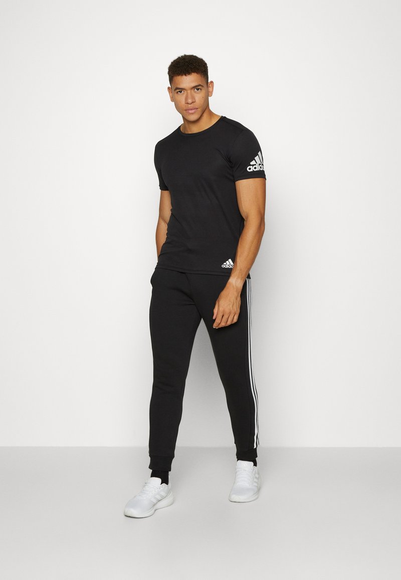 adidas Sportswear adidas Sportswear ESSENTIALS TAPERED CUFF 3 STRIPES PANTS - Tracksuit bottoms - black white Schlussverkauf